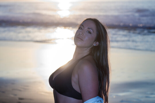 Woman posing on beach during golden hour sunset