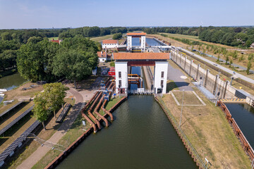Fototapeta premium Aerial of sluice gate between river IJssel and Twentekanaal in Dutch landscape with water pumping machinery station tubes