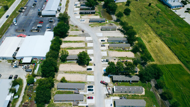 Commercial warehousing facilities border residential housing blocks near major transit intersections. Overhead capture traces transition zones connecting industrial parcels to New Braunfels, TX