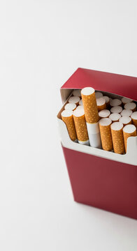 Close-up of a red pack filled with cigarettes, showcasing its contents against a plain background, symbolizing habit or vices