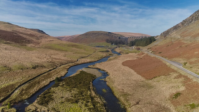 Winding river cuts through rugged, brown hills