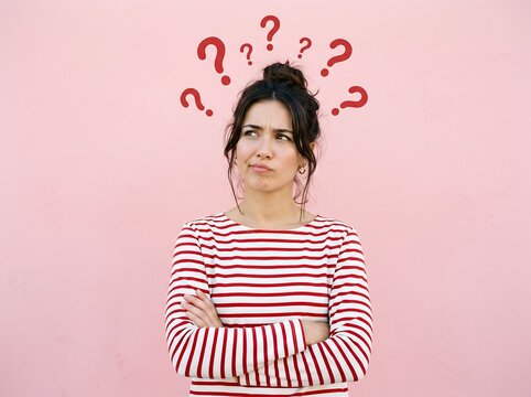 Confused Young Woman Surrounded By Red Question Marks On Pink