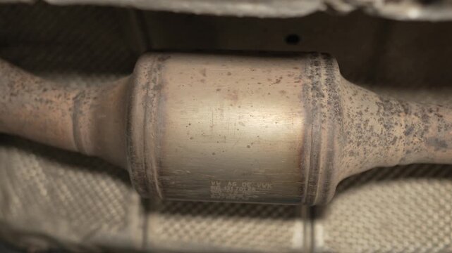 A car catalytic converter is mounted on the exhaust pipe.