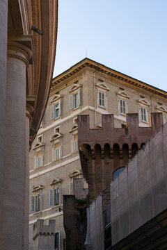 Fachada de edificio hist&oacute;rico en el Vaticano con detalles arquitect&oacute;nicos cl&aacute;sicos, ventanas con persianas, una gran columna y andamios de restauraci&oacute;n estructural
