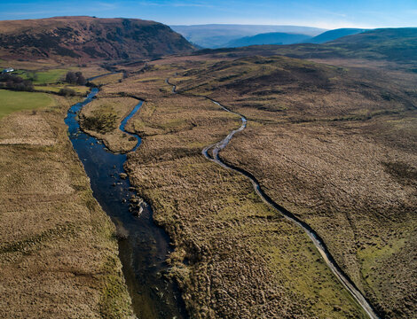River winds through rugged, earth-toned moorland