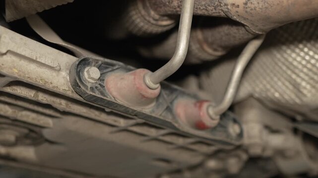 An exhaust pipe rubber hanger bracket is mounted under car.