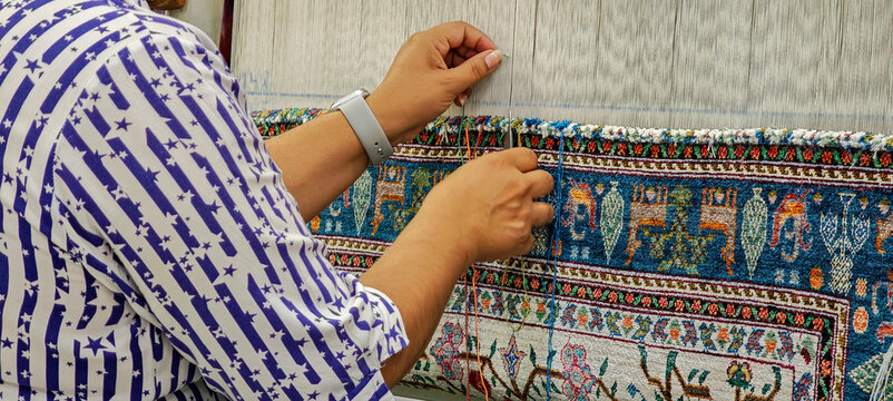 Women weaving a silk carpet on a factory of Bukhara on Uzbekistan