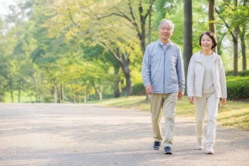 Obraz premium 秋の公園を散歩する元気な日本人シニア夫婦