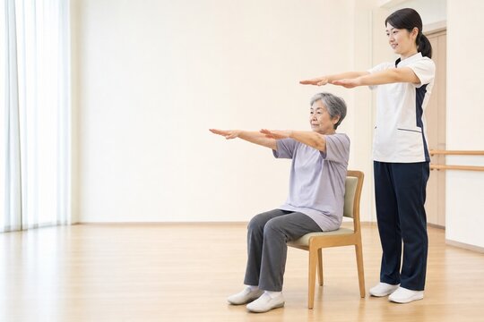 椅子に座って上肢リハビリをする日本人シニア女性