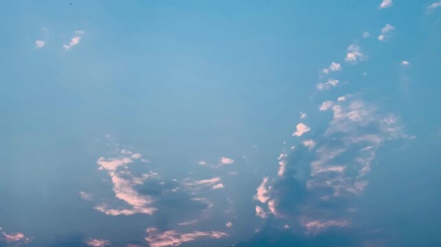 4K footage of dramatic blue clouds illuminated by soft sunlight filtering through the sky over Jakarta, Indonesia. Slow left-to-right camera movement creates a calm cinematic atmosphere suitable for n