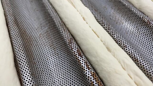 Raw yeast dough products before entering the oven. Rest during the final proofing stage, showcasing professional French baguettes production and traditional bread making process.