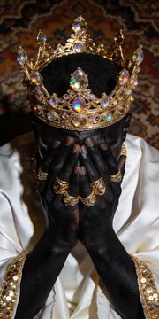 Cinematic portrait of a Black king wearing an ornate jeweled golden crown and rings, covering his face in grief