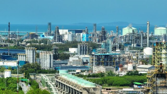 Coastal industrial landscape captured from above, revealing interconnected petrochemical facilities, energy infrastructure, and maritime operations amid the global shift toward decarbonization. 4k.
