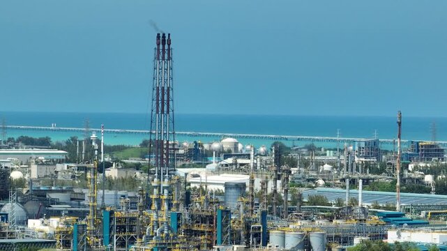 A coastal petrochemical industrial complex with refinery units, flare stacks, and energy infrastructure, highlighting maritime logistics, heavy industry scale, the transition toward cleaner energy.

