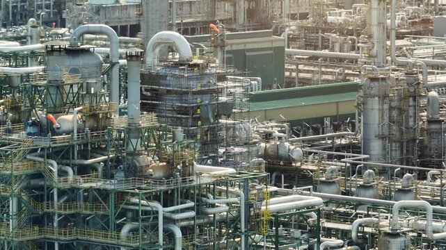 Aerial industrial showing a massive petrochemical processing plant with towers, pipelines, and equipment systems, illustrating heavy industry, manufacturing capability and global energy supply chains.