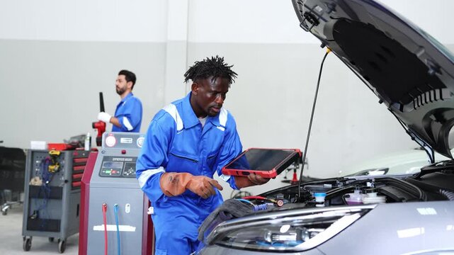 Automotive technician diagnosing engine issues with diagnostic tool in a modern workshop environment