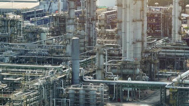High-angle aerial view of chemical refining facilities showcasing extensive piping systems, operational integrity, and advanced industrial technology supporting large-scale production. 4k.
