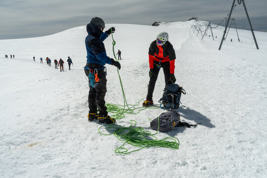 Mountaineers preparing for glacier trekking on a snowy mountain landscape