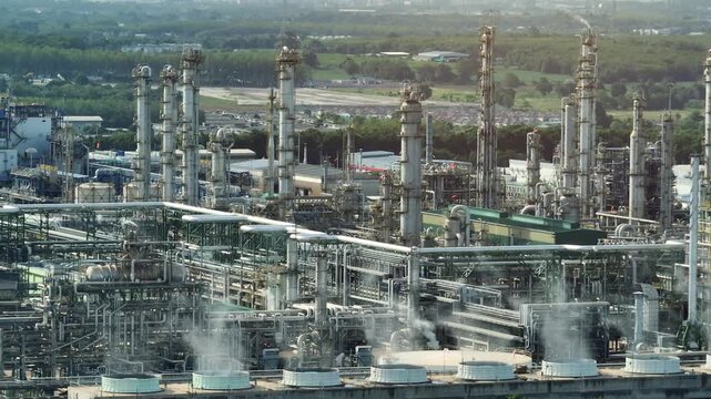Wide aerial shot of an eco-industrial complex with cooling towers and vapor emissions, showcasing sustainable water use, thermal efficiency, and green belt coexistence. 4k.
