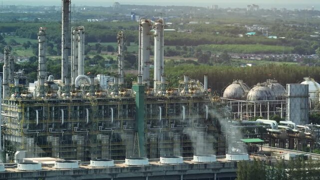Industrial aerial view showing cooling tower vapor plumes and processing facilities, highlighting water stewardship strategies, ecological zoning, and cleaner industrial practices. 4k.
