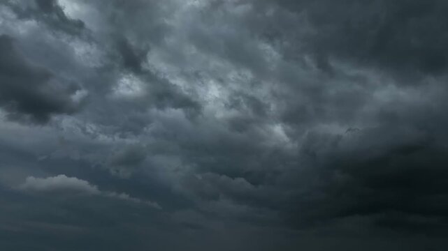Aerial view of dark storm clouds creating a dramatic atmospheric background, symbolizing extreme weather, climate change crisis, climate resilience, and disaster preparedness strategies. 4k.
