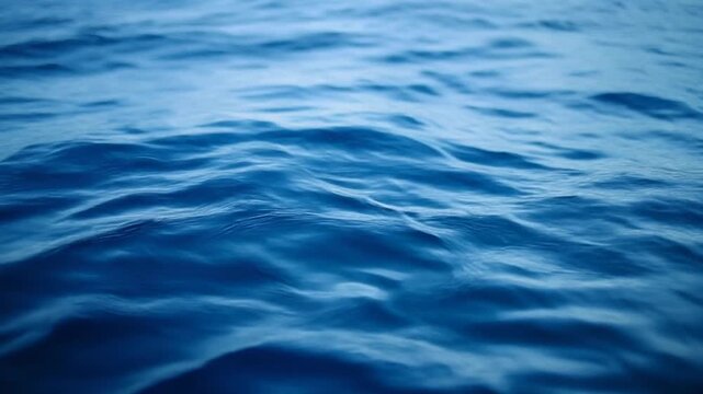 Calm blue ocean water surface with gentle ripples during daylight with soft lighting for serene backgrounds