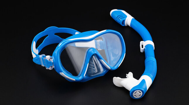 Blue diving mask and snorkel on black background.