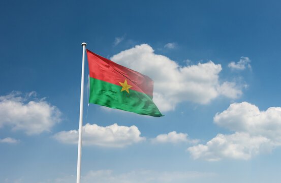 Burkina Faso flag waving in beautiful sky.