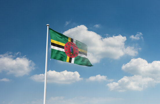 Dominica flag waving in beautiful sky.