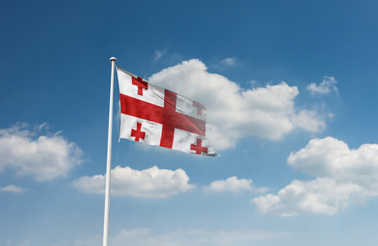 Georgia flag waving in beautiful sky.