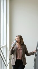 Fototapeta premium Businesswoman Drinking Water In Office Stairwell