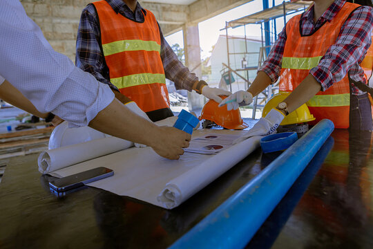 Structural engineer and architect and foreman worker with blueprints discuss, plan working for the building construction site office. Construction collaboration concept