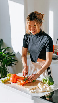 Beautiful Asian Woman Preparing Fresh Vegetables in a Bright Modern Kitchen