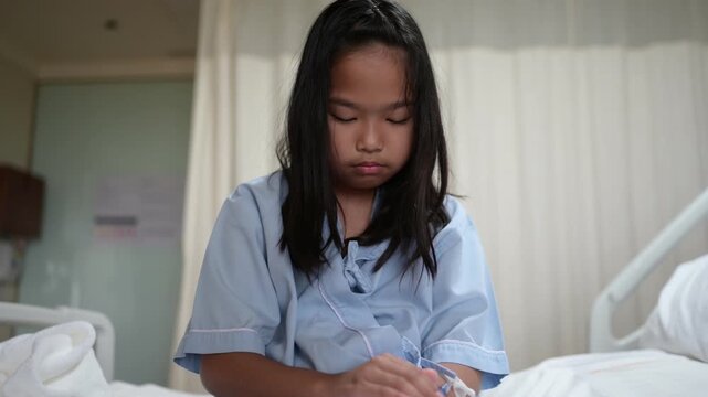Female patient sits on a hospital bed beside an IV infusion pump while receiving medical care. Concept of hospitalization, healthcare, patient recovery, treatment, and clinical care.
