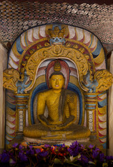 Fototapeta premium Golden Buddha statue inside a traditional Buddhist temple with ornate decorations