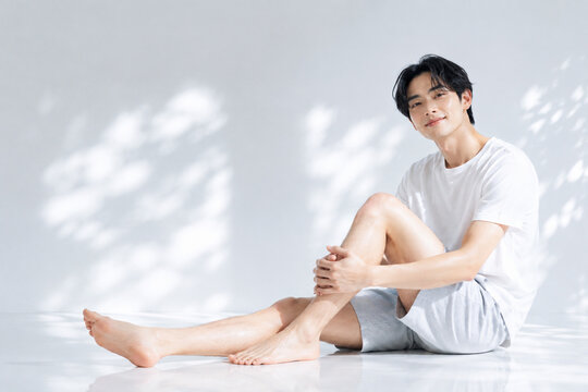 メンズ脱毛のイメージ-足を伸ばして座る男性