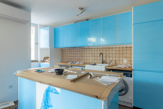 Modern Kitchen Renovation in Progress with Bright Cabinets, Ceramic Tile Backsplash, and Unfinished Island. Home Improvement Project, Interior Design, Remodeling Concept for Real Estate and DIY
