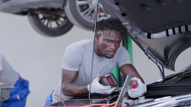 Auto technician troubleshooting vehicle problems using diagnostic equipment in a car repair workshop