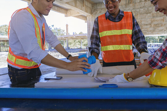 Structural engineer and architect and foreman worker with blueprints discuss, plan working for the building construction site office. Construction collaboration concept