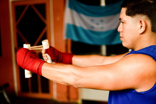 Young man practicing boxing with hand training tool