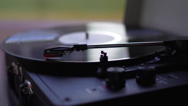 Close up of black vinyl record spinning on vintage turntable record player