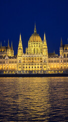 Fototapeta premium Stunning view of the illuminated Hungarian Parliament building at night in Budapest
