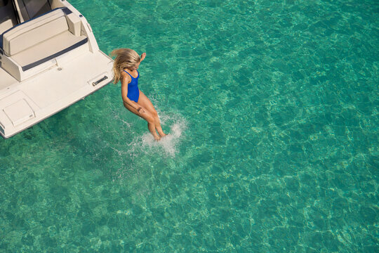 A woman jumping off a boat into the ocean