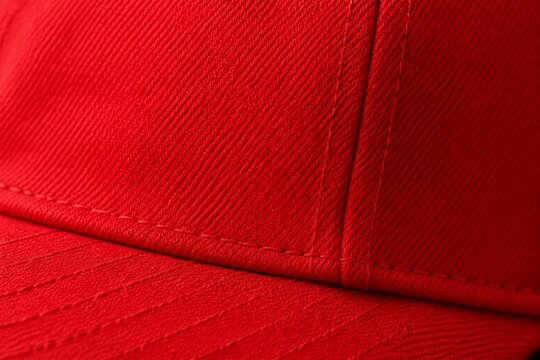Red baseball cap close up textile texture on neutral background