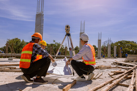 Structural engineer, architect and foreman worker with blueprints discuss, plan working for the outdoors building construction site. Construction collaboration concept