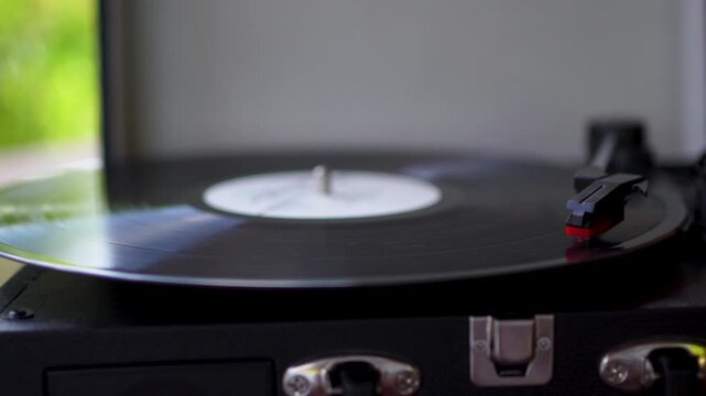 Close up of black vinyl record spinning on vintage turntable record player