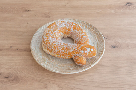 Sugar-Coated Italian Graffa Pastry Served on a Textured Ceramic Plate