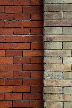 Corner junction of red brick and pale stone walls meeting at vertical seam
