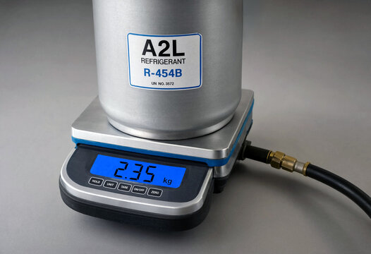 Cylinder of R-454B A2L refrigerant on a digital scale with a connected hose.