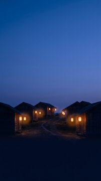 Small wooden cabins with glowing warm lanterns in a quiet village at night time